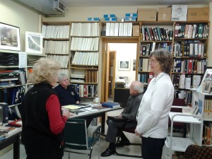 Ruth Dougherty (left) and Joan Benoit chat in front of Earl John Chapman who is seated at the table speaking with Oskar Keller.